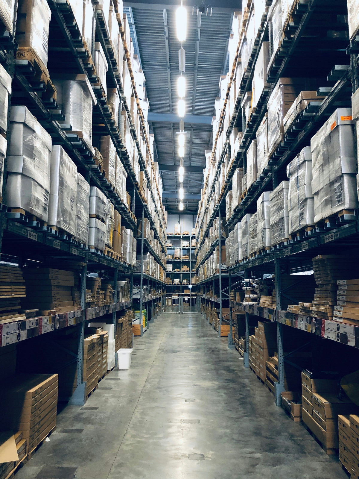 Long warehouse aisle with boxes on tall storage shelves