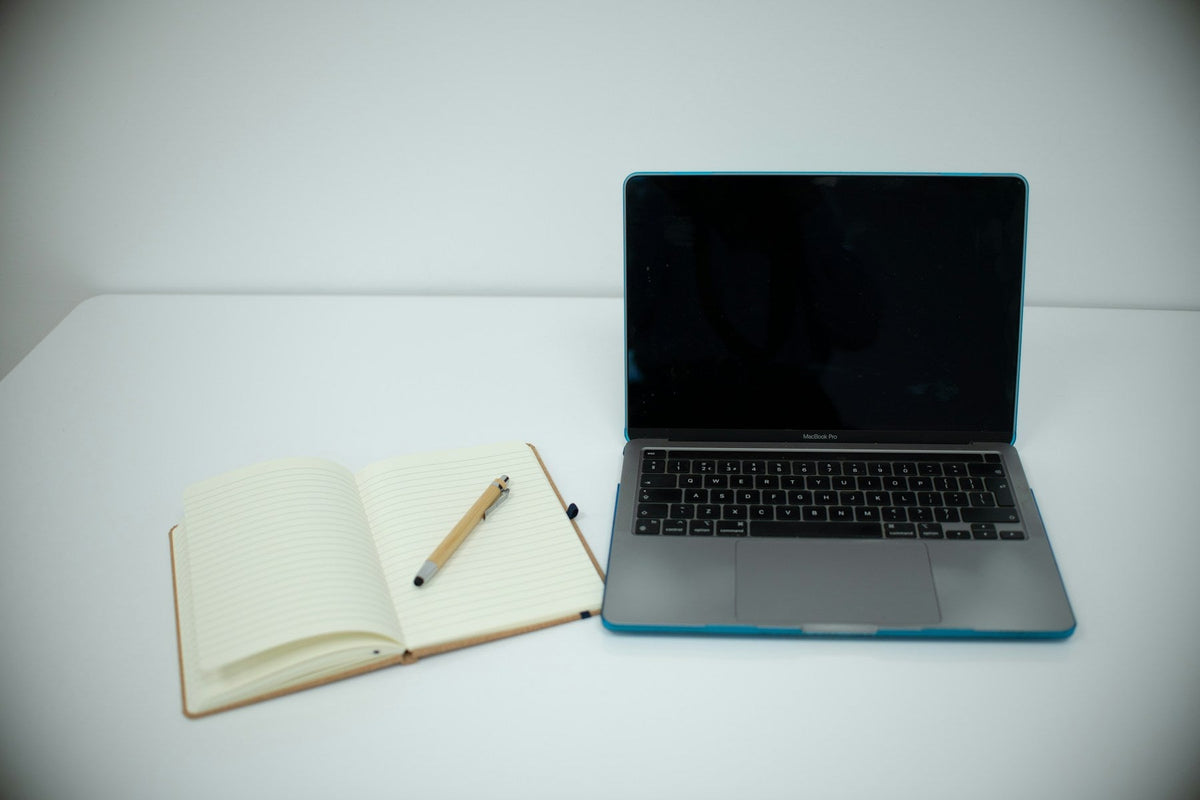 Laptop and open notebook on a desk for planning meetings