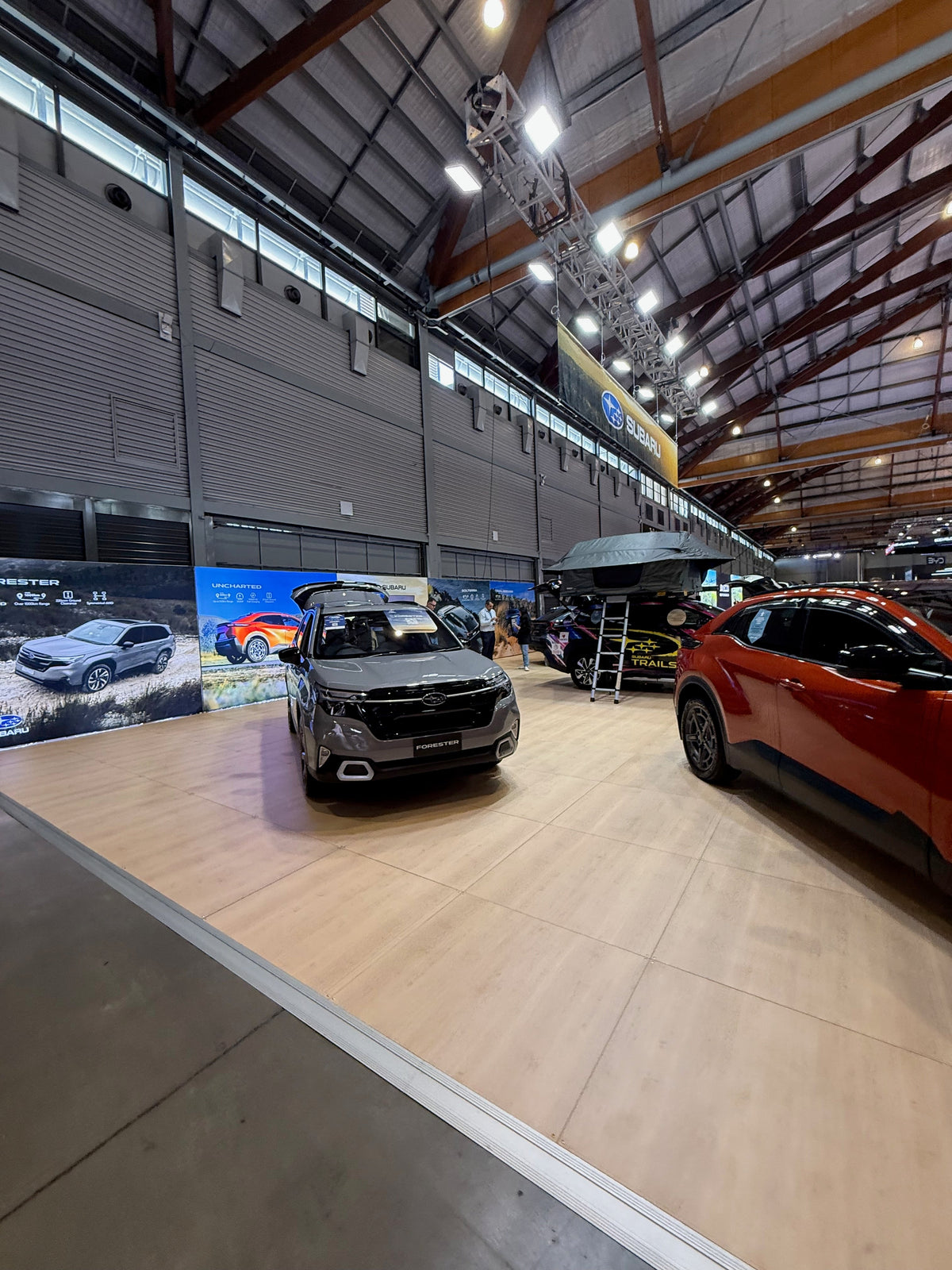 Subaru at Everything Electric 2026: a vehicle display built around five illuminated walls — Subaru booth at Everything Electric 2026 with illuminated vehicle graphics and display cars